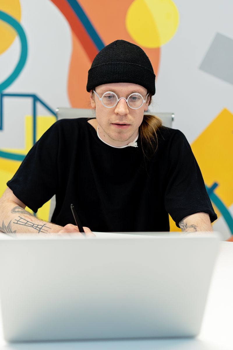 A freelance designer working on a laptop in a bright studio