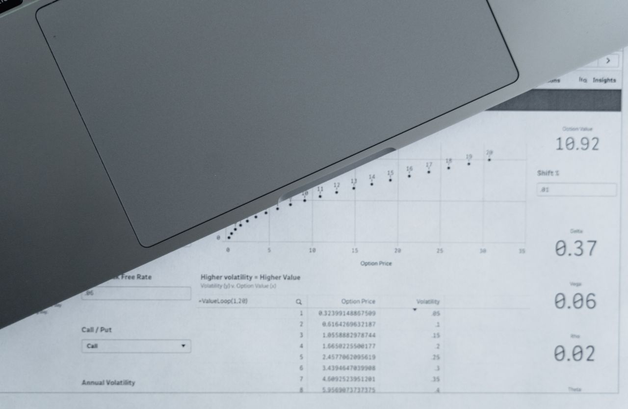 A printed financial report on a desk beside a laptop